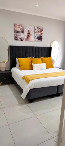 a bedroom with a large bed with yellow pillows at The Haven in Nelspruit