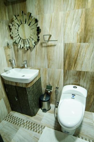 a bathroom with a toilet and a sink at Newtown Inn in Hulhumale