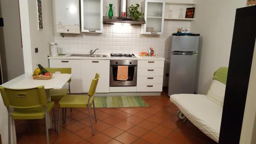 a kitchen with a stove and a table with chairs at Casa Belfiore Da Andrea in Ferrara