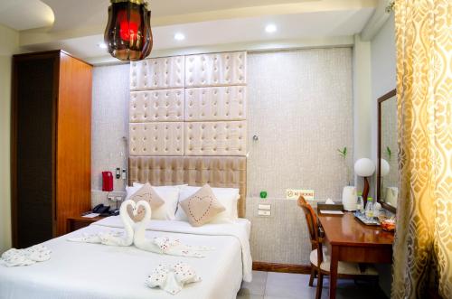 a hotel room with two swans sitting on two beds at Newtown Inn in Hulhumale