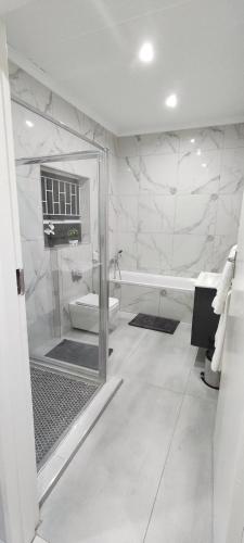 a bathroom with a glass shower and a toilet at The Haven in Nelspruit