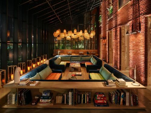 a library with a couch and a table with books at The Asbury Hotel in Asbury Park