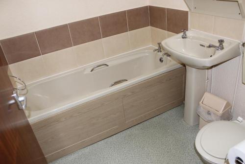 a bathroom with a tub and a sink and a toilet at The Premier Lodge in Morpeth