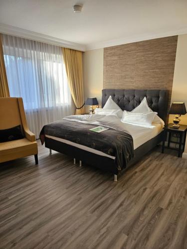 a hotel room with a large bed and a chair at Business & More Boutique Hotel Hamburg in Hamburg