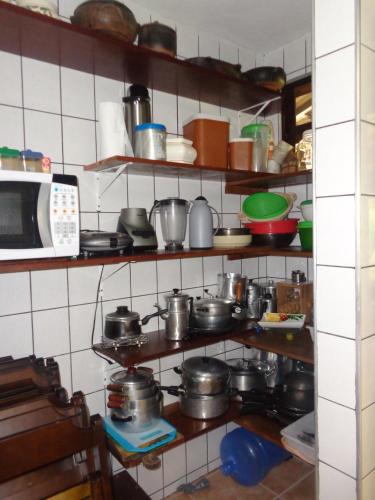 a kitchen with pots and pans and a microwave at Trindade Casa Amarela in Trindade
