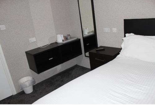 a hotel room with a bed and a mirror at The Premier Lodge in Morpeth