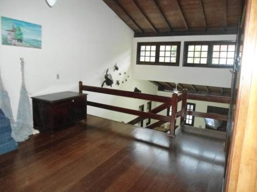 a living room with a wooden floor and a staircase at Trindade Casa Amarela in Trindade