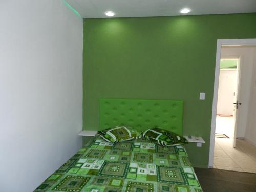 a green bedroom with a bed with a green wall at Magias da Serra in Canela