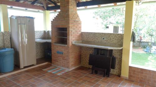 a brick fireplace in a kitchen with a stove at Trindade Casa Amarela in Trindade