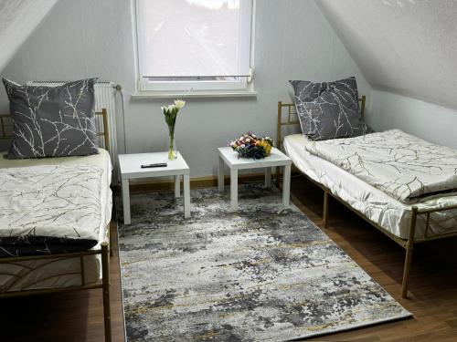 a room with two beds and a table and a window at Schelder Unterkunft in Dillenburg