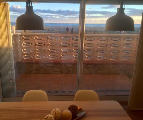 una mesa con sillas y una ventana con vistas. en Don Ernesto, en Castelldefels