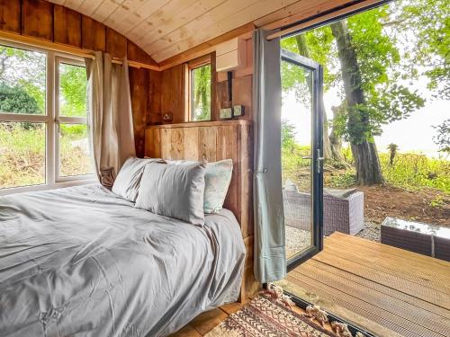 a bedroom with a bed and a sliding glass door at Coastal Views in Cloughton