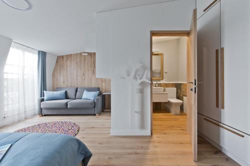 a bedroom with a bed and a living room with a couch at Aura apartamentai in Druskininkai