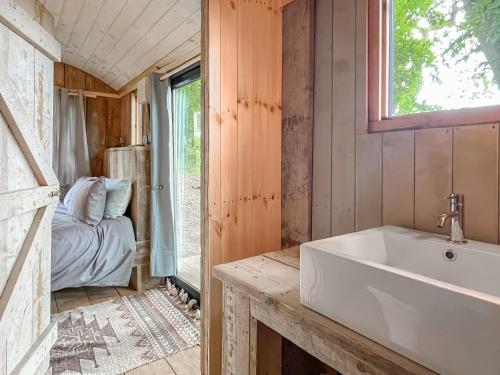 a bathroom with a white tub and a bedroom at Coastal Views in Cloughton
