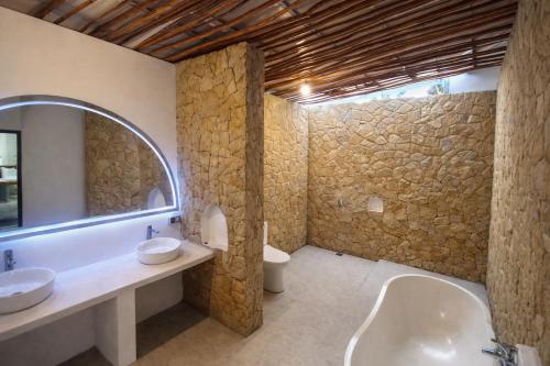 a bathroom with two sinks and a large mirror at Segara Hill Villa in Senggigi