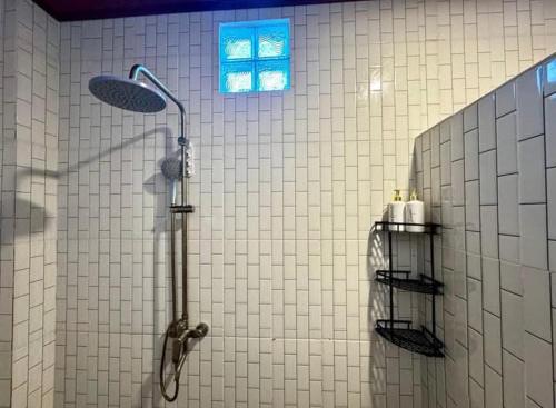 a bathroom with a shower with a blue window at Diana House in Amed in Amed