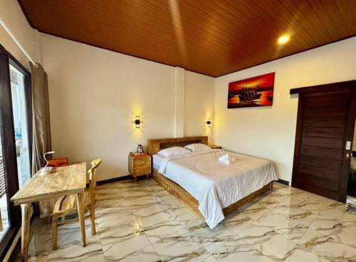 a bedroom with a bed and a table in a room at Diana House in Amed in Amed