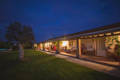 a house with a tree in the yard at night at Monte Chalaça - Turismo Rural in Ferreira do Alentejo