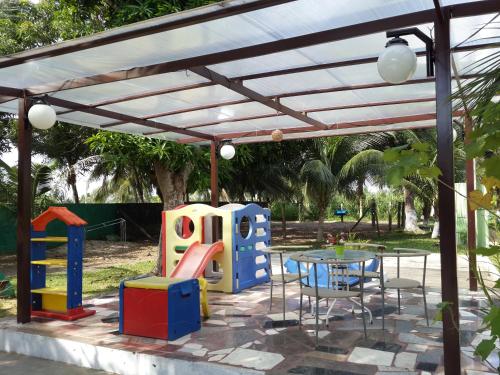 uma pérgola com uma mesa e um parque infantil em Chacara Santa Barbara em Manaus