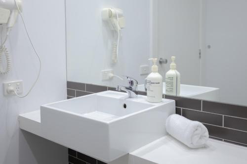 a white bathroom with a sink and a shower at Bay View Ocean Breeze in Lorne