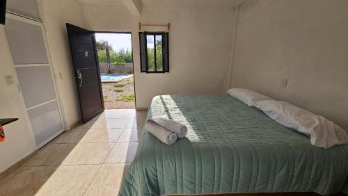a bedroom with a bed with a green comforter at Hospedaje Tecmilco in Tepoztlán