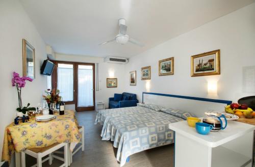 a hotel room with a bed and a dining table at Residence Villa Rosa in Garda