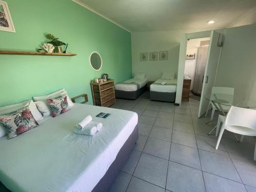 a bedroom with a bed and a room with a table at Forest Gate Apartments and Rooms in Plettenberg Bay