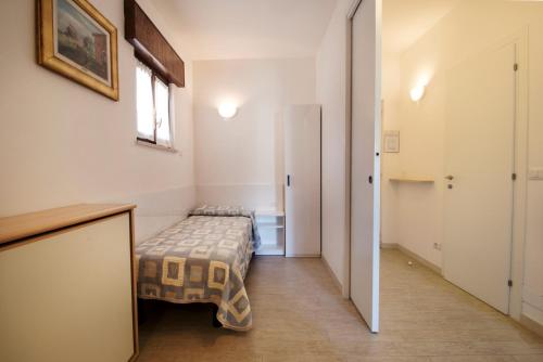 a small room with a bed and a hallway at Residence Villa Rosa in Garda