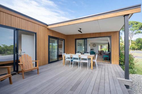 a wooden deck with a table and chairs on it at Pohara's Beach Escape in Pohara