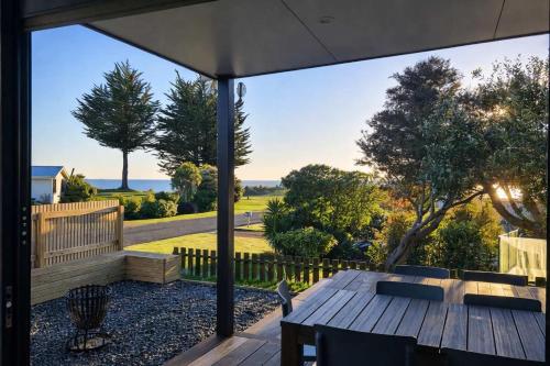 an outdoor patio with a wooden table and chairs at Pohara's Beach Escape in Pohara