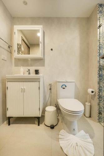 a bathroom with a toilet and a sink and a mirror at Studio Apartment by the Sea E413 in Phuket
