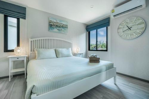 a bedroom with a bed with a large clock on the wall at Studio Apartment by the Sea E413 in Phuket