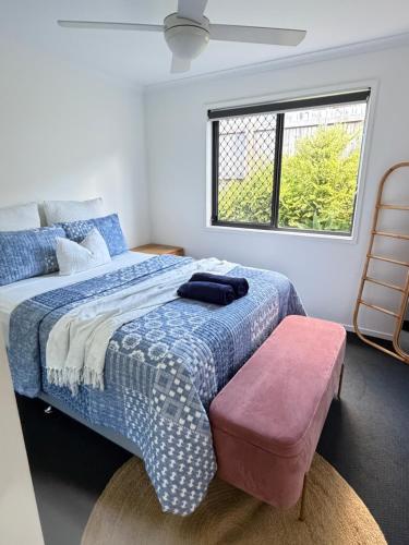 a bedroom with a bed with a blue and white comforter at JOT Luxe Haven in Narangba