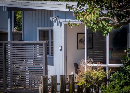 a house with a white door and a fence at Pohara's Beachside Gem in Pohara