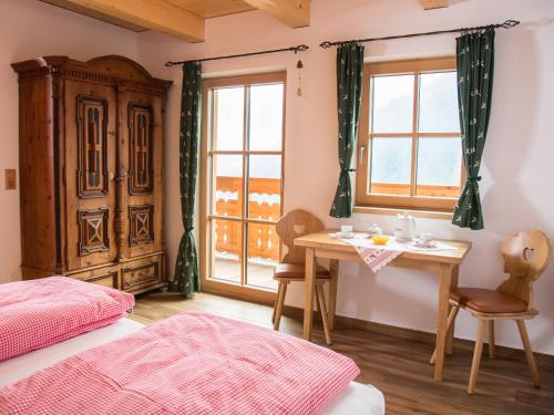 a bedroom with a table and a window at Landhof Adlerhorst in Heiligenblut