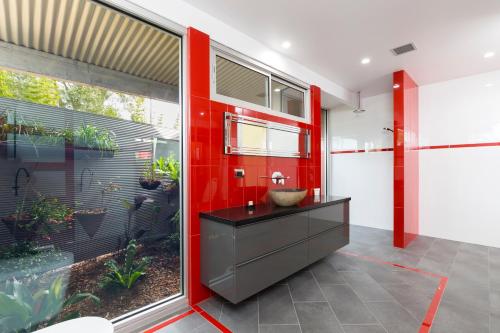 a bathroom with a sink and a red wall at Mt Hay Retreat in Berry