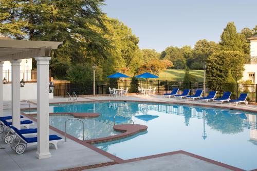 a large swimming pool with blue chairs and chairs at Williamsburg Inn, an official Colonial Williamsburg Hotel in Williamsburg