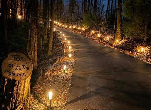 a road with candles and lights in the woods at Top of the Mountain Breathtaking Views Hot Tub in Blue Ridge