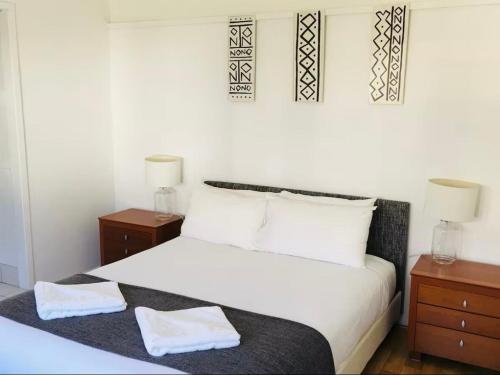 a bedroom with a white bed with two night stands at Ocean Studio along Shelly Beach in Sydney