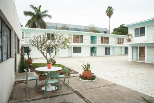 a courtyard with a table and chairs and a building at Hotel La Siesta, Gomez Palacio in Gómez Palacio