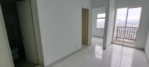 an empty room with a large window and white tile floor at Apartement ayodhya 2BR Unfurnished in Tjikokol