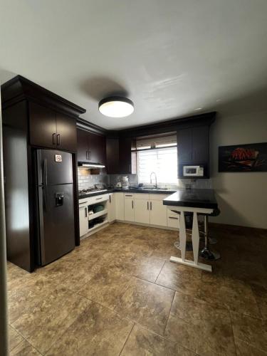 a kitchen with a refrigerator and a table in it at Loft A cerca zona dorada in Mexicali
