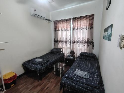 a room with two beds and a window at Private Room in Condominium - Sandakan Friend House in Sandakan