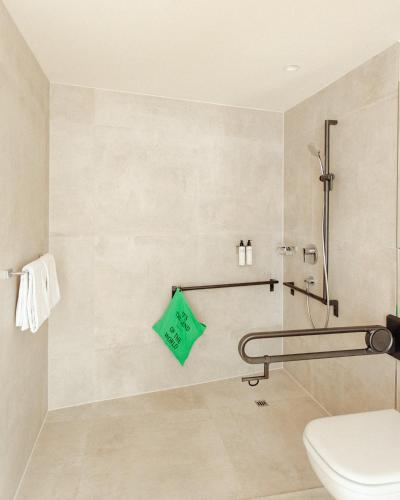a bathroom with a toilet and a green towel at Lendhotel in Graz