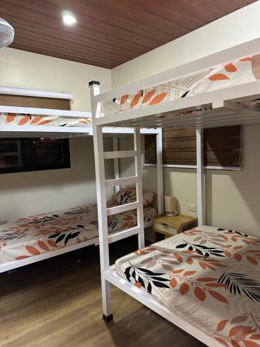 a bedroom with two bunk beds and a desk at SeventhHeaven Nasugbu in Reparo