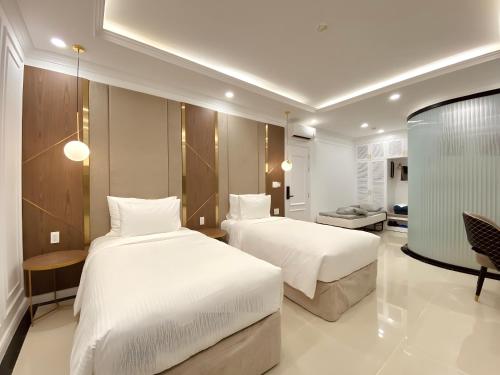 a hotel room with two beds and a table at Leto Hotel Central Sunset Town in Phú Quốc