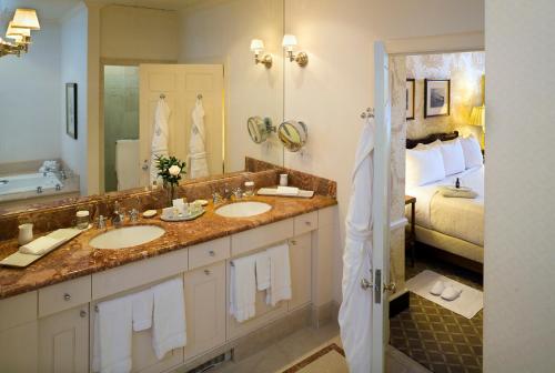 a bathroom with two sinks and a bed at Williamsburg Inn, an official Colonial Williamsburg Hotel in Williamsburg