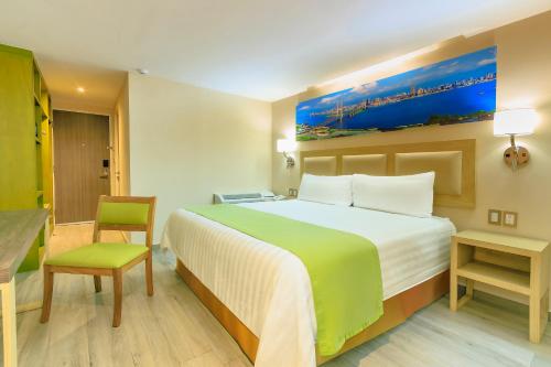 a hotel room with a large bed and a chair at Collection O Hotel Paris FC, Veracruz in Veracruz