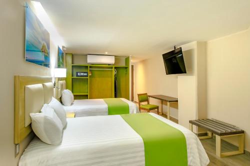 a hotel room with two beds and a television at Collection O Hotel Paris FC, Veracruz in Veracruz