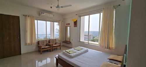 a living room with a table and large windows at Konark Villa in Mahabaleshwar
